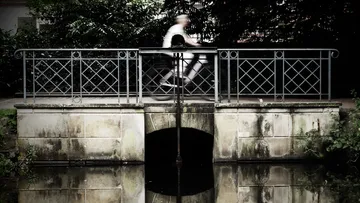 Person radelt über eine kleine Brücke.