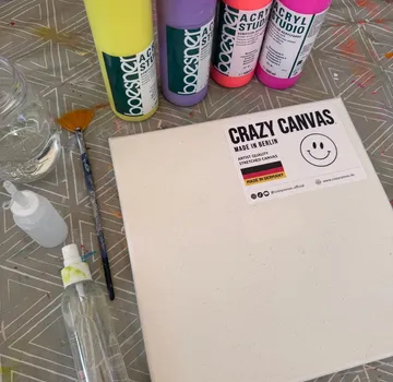 Canvas and paints on patterned tablecloth.