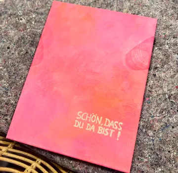 Pink invitation card on textured surface.