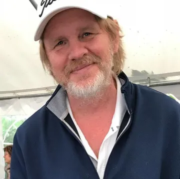 Mann lächelt, trägt Kappe, Innenaufnahme.