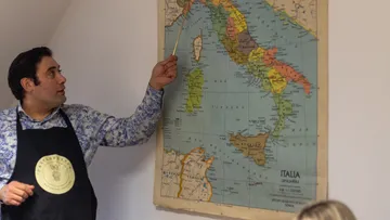 Mann zeigt auf Italienkarte an Wand.