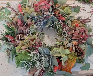 Wreath made of dried flowers on table.