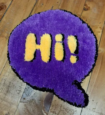 Lila Teppich sagt 'Hi!' auf Holzboden.