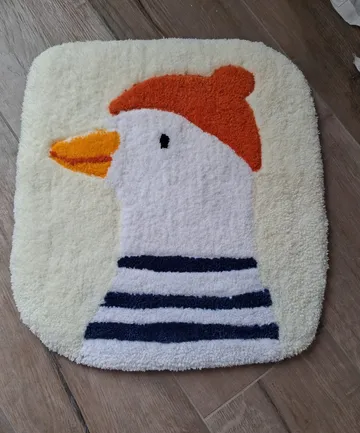 Entenillustration auf quadratischem weißen Teppich.