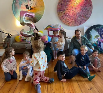 Children holding balloons, celebrating indoors.