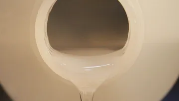 Liquid pouring from container into bottle.