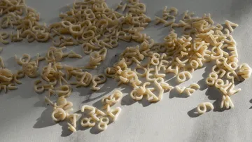 Buchstaben-Nudeln auf einem Tisch verstreut.