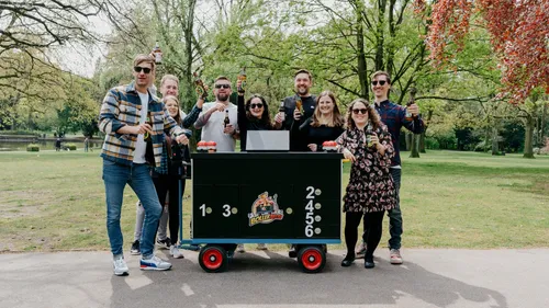 Gruppe feiert mit Getränken um Wagen im Park.