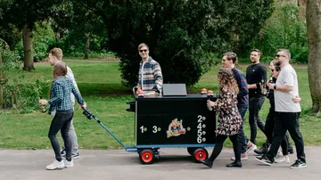 Menschen schieben einen Wagen im Park.