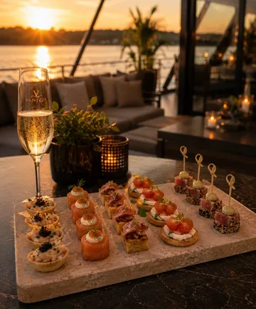 Appetizers on a stone platter, sunset background.