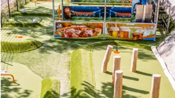 Minigolfplatz mit Holzhindernissen im Freien.