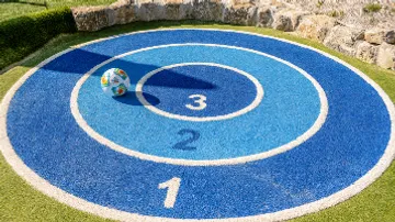 Bunter Ball auf blauem Zielkreis im Freien.