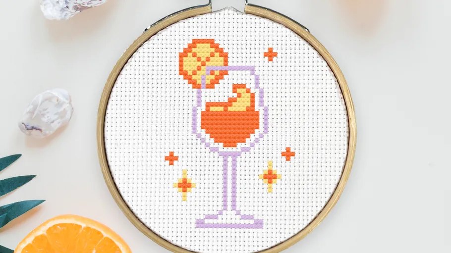 Cross-stitch cocktail hoop with orange slice.
