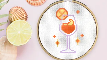 Kreuzstich-Cocktail umgeben von Muscheln.