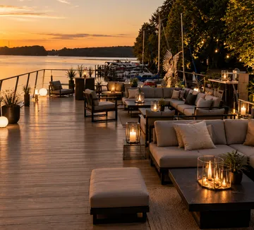 Outdoor seating with candles at sunset by a river.