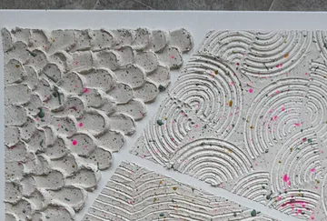 Textured plaster art with colorful speckles.