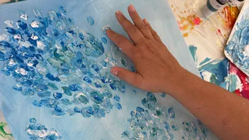 Hand painting with blue and white paint.