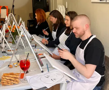 Menschen malen an einem Workshop-Tisch.