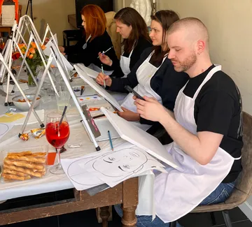Menschen malen bei einem Tisch-Workshop.