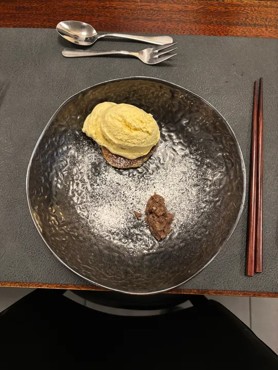 Eiscreme auf Dessertteller mit Besteck.