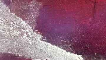 Strukturierte Wand mit roter und weißer Farbe.