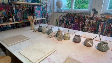 Maltisch im Kunststudio mit Farbtöpfen