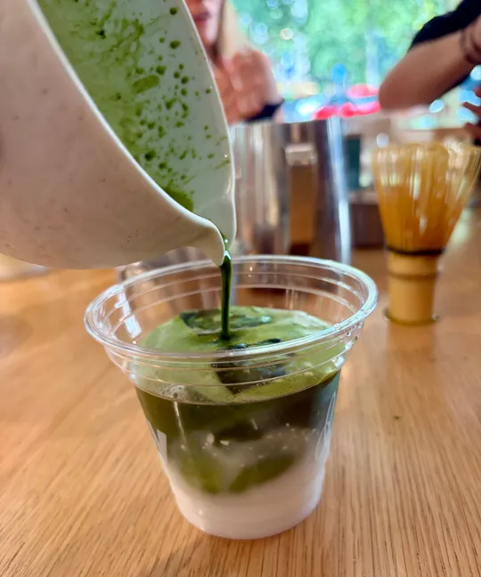 Grüner Tee in Plastikbecher gegossen.