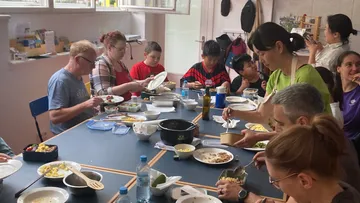 Personen essen Mittagessen an einem Tisch.