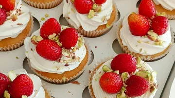 Cupcakes mit Erdbeeren und Pistazien belegt.