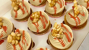 Cupcakes topped with caramelized nuts and sauce.