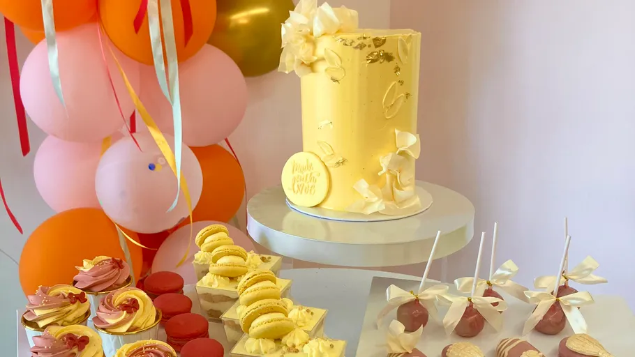 Gelber Kuchen mit Desserts, Ballonhintergrund.