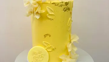 Yellow cake decorated with white flowers.