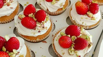 Cupcakes topped with strawberries and nuts.