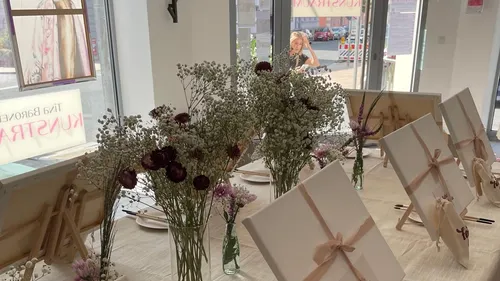 Canvases on easels with floral decorations.