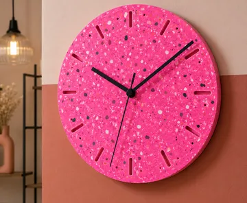 Pinker Wanduhr mit gesprenkeltem Muster.