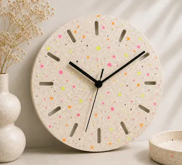 Bunte gesprenkelte Wanduhr auf Regal.
