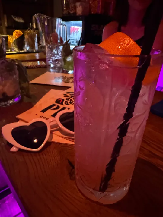 Cocktail with orange slice on bar counter.