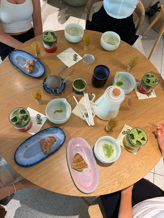 Tisch mit Matcha-Desserts und Getränken.