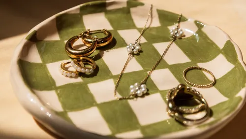 Jewelry pieces on a checkered ceramic dish.