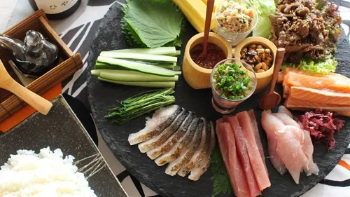 Sushi ingredients arranged on a dark platter.