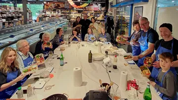 Group holding meals at workshop table.
