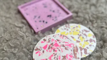 Colorful terrazzo coasters on fuzzy surface.