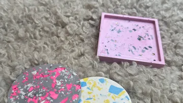 Bunte Untersetzer auf strukturiertem Teppich.