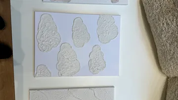 Textured art pieces on a white table.