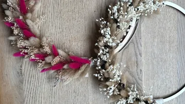 Blumenring mit rosa Akzenten auf Holzboden