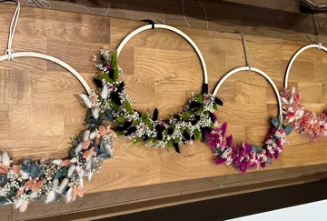 Floral wreaths displayed on wooden wall.