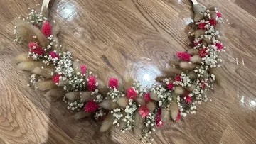 Floral wreath resting on wooden floor.