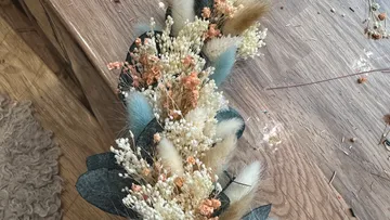 Dried floral arrangement on wooden table.