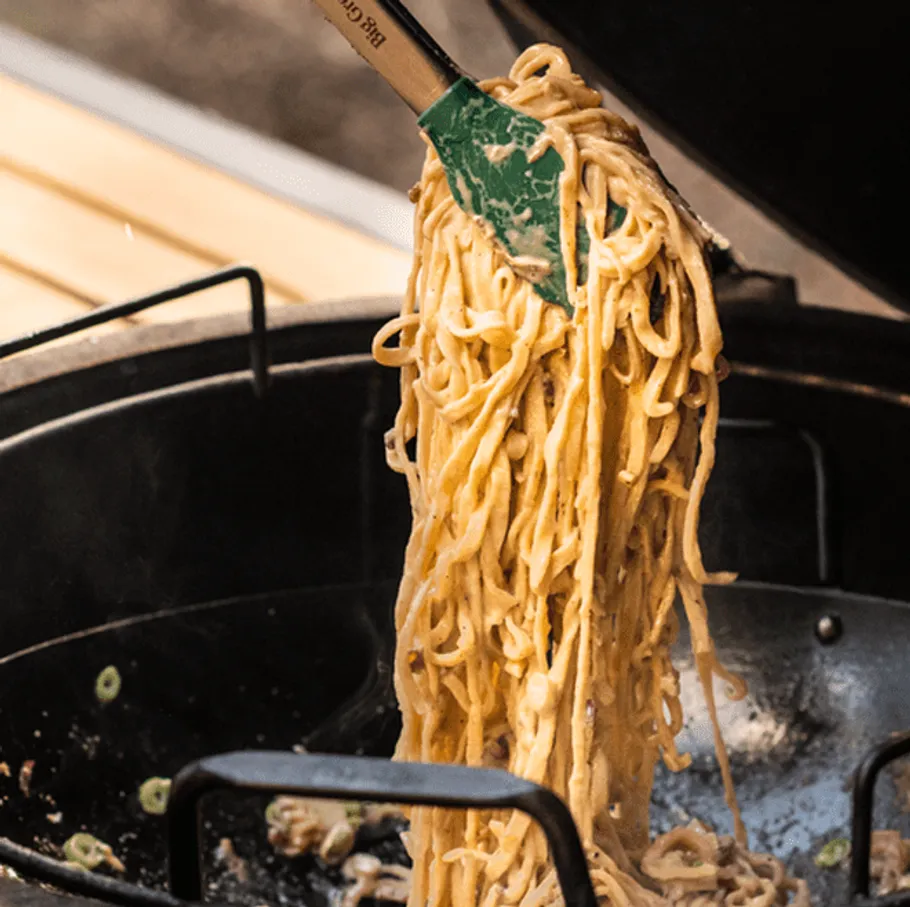 Pasta is lifted out of a pot with a spatula.