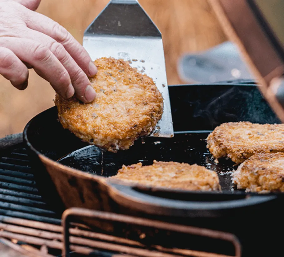 Pan with fried patties, someone picks out a patty.